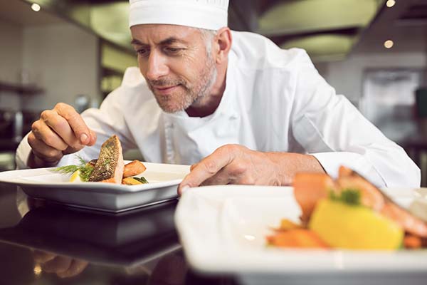 chef garnishing food in the kitchen