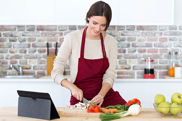 woman cooking and using a digital tablet