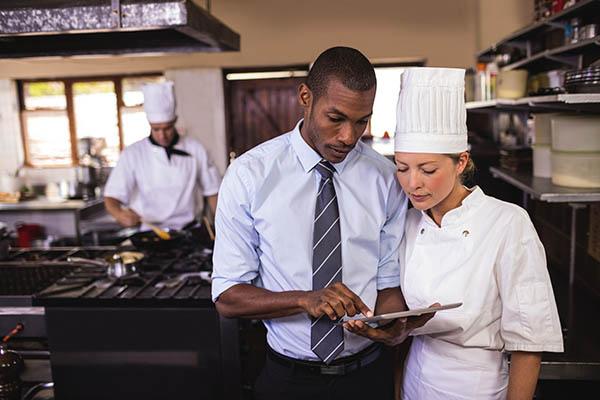 kitchen staff using a tablet