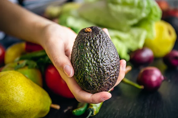 avocado in hand on a blurred background