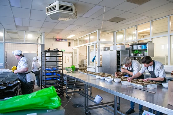 chefs preparing food in a commercial kitchen