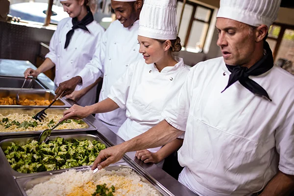 group of chefs stirring prepared foods in kitchen