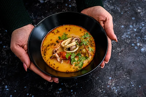 spicy seafood soup with squid and fresh herbs