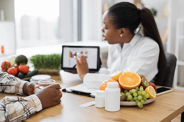 uk food labelling regulation featured image - nutritionist holding a tablet explaining something to her client