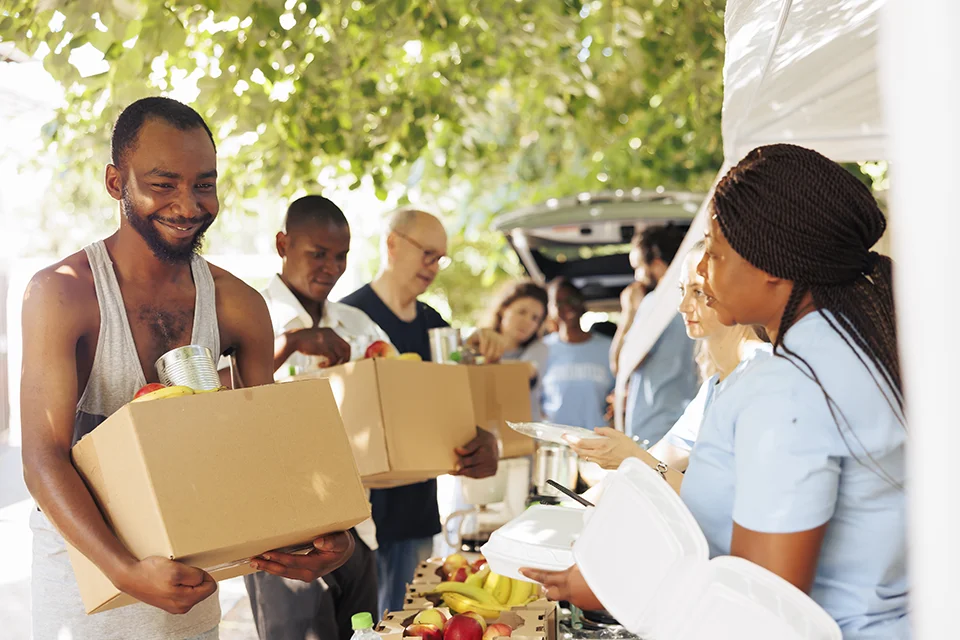 people volunteering and distributing food at outdoor event