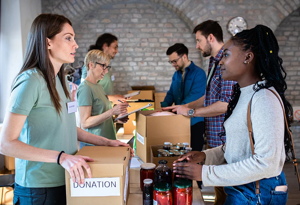 volunteers sorting donations into boxes inside building